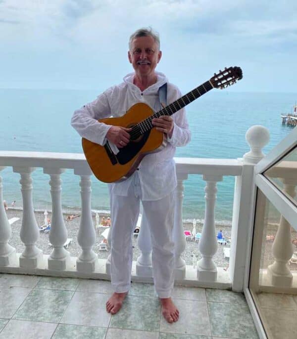 Бард Александр Косенков с гитарой в белом